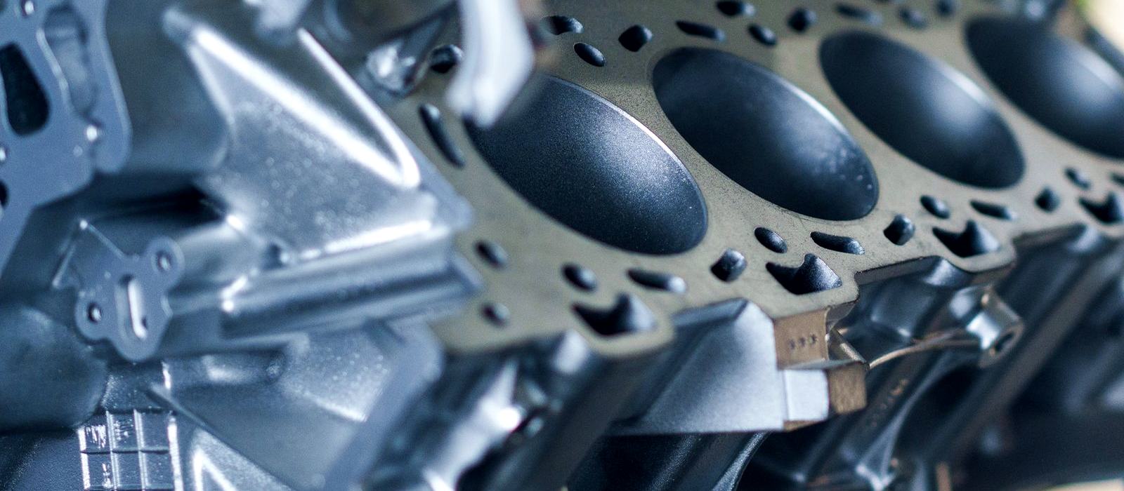 An engine block with its cylinder bores lit from the side